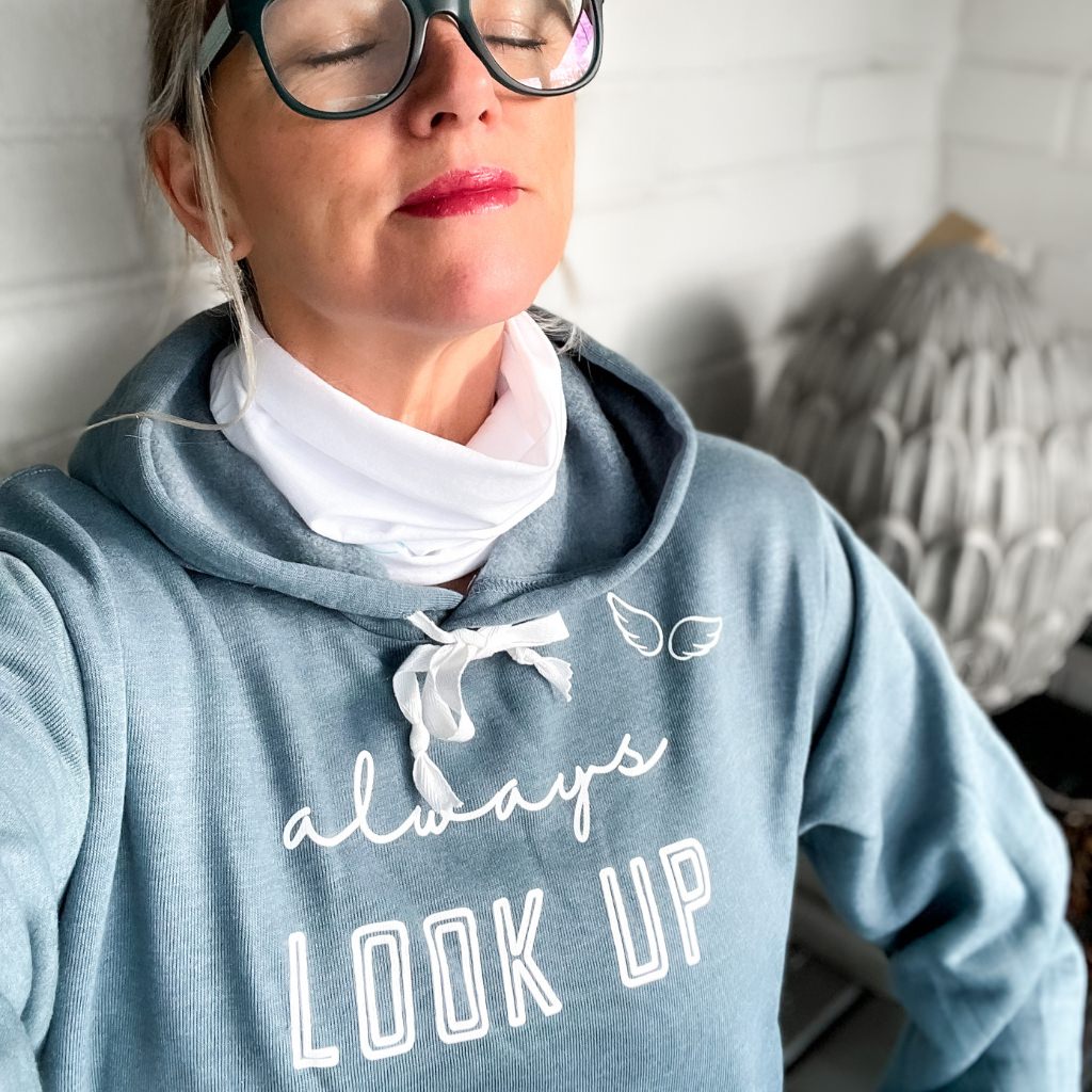 super soft hoodie with screen printed image in white ink that says 'always LOOK UP' with little wings near the shoulder.  woman looking up cozy sky blue hoodie.  unisex hoodie.  motivational & uplifting hoodie.