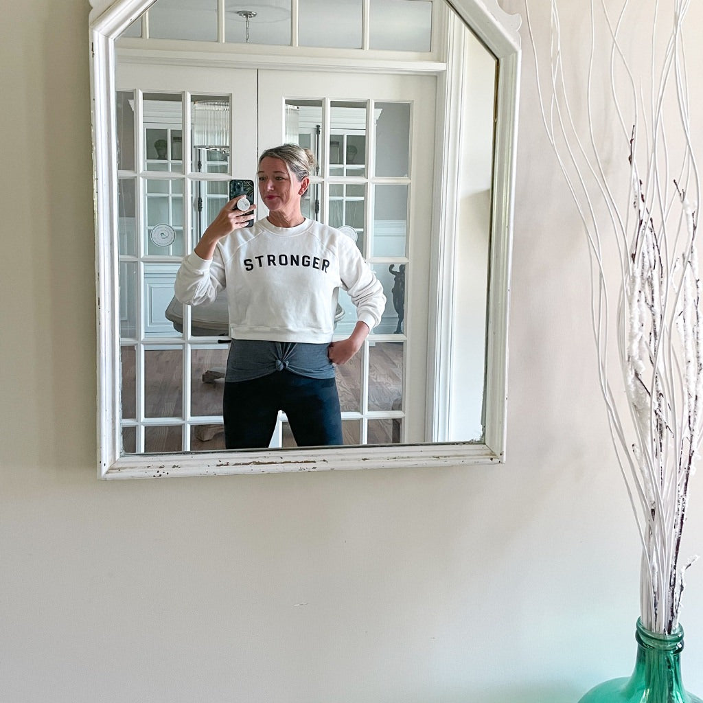 stronger black text saying on vintage white crop sweatshirt.  woman wearing active sweatshirt with stronger every day saying.  womens crop sweatshirt with leggings & tank top active style.