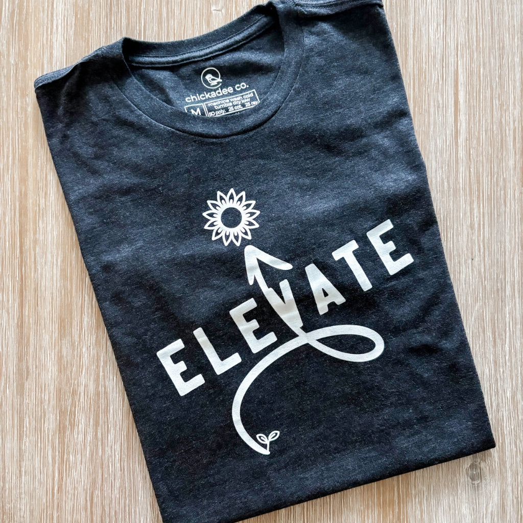 the word elevate printed on a super soft unisex triblend tshirt.  vintage black tshirt with white ink print.  motivational & intentional tshirt.