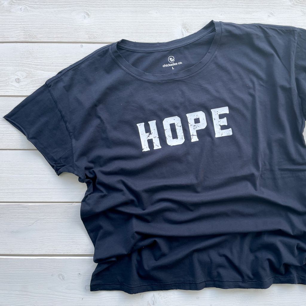 HOPE printed in white ink on relaxed black cotton tshirt for women.  distressed print in white on black tee saying HOPE.