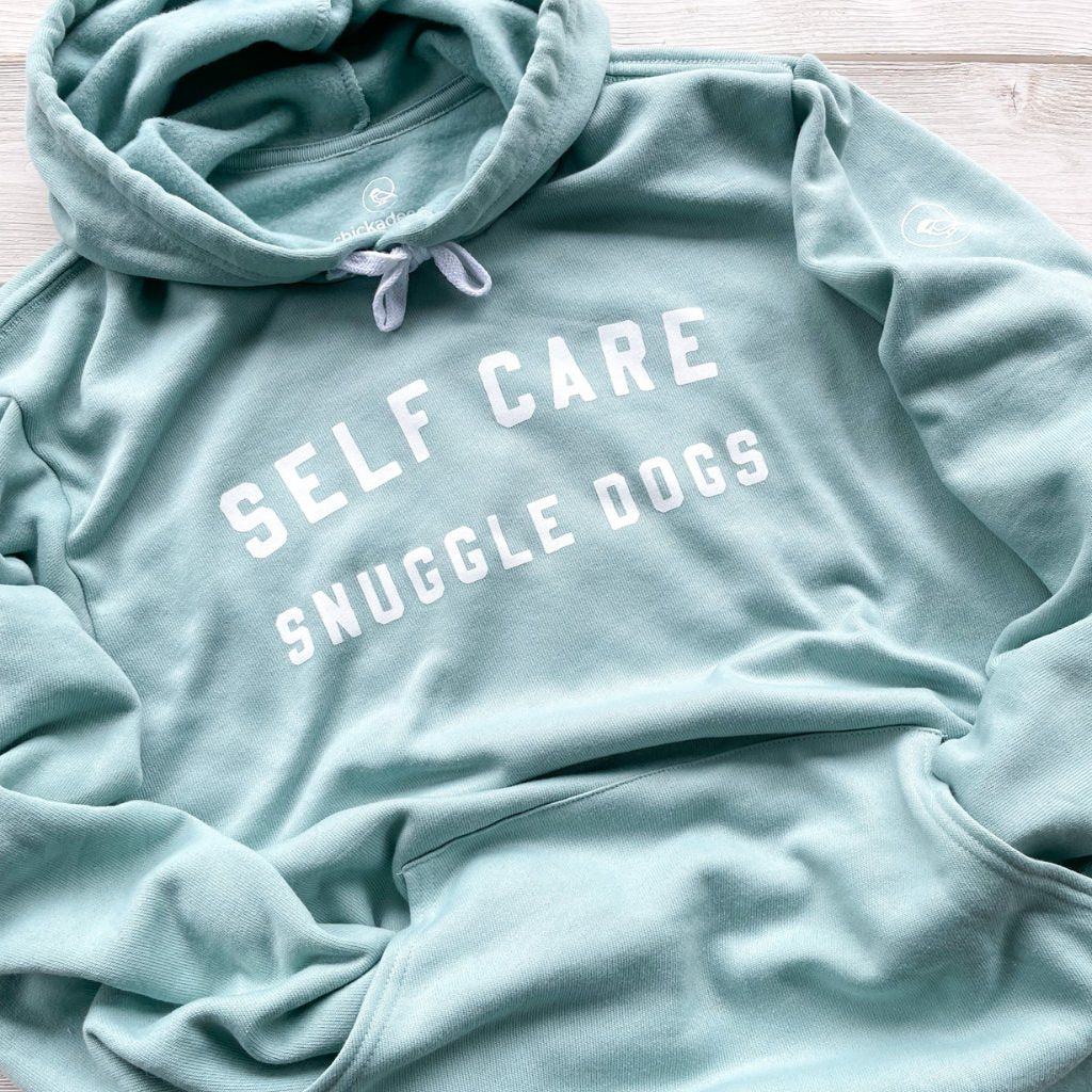 self care snuggle dogs white text saying on light sea green hoodie sweatshirt.  dog apparel.  dog hoodies for humans.  super soft hoodie sweatshirt for dog lovers.