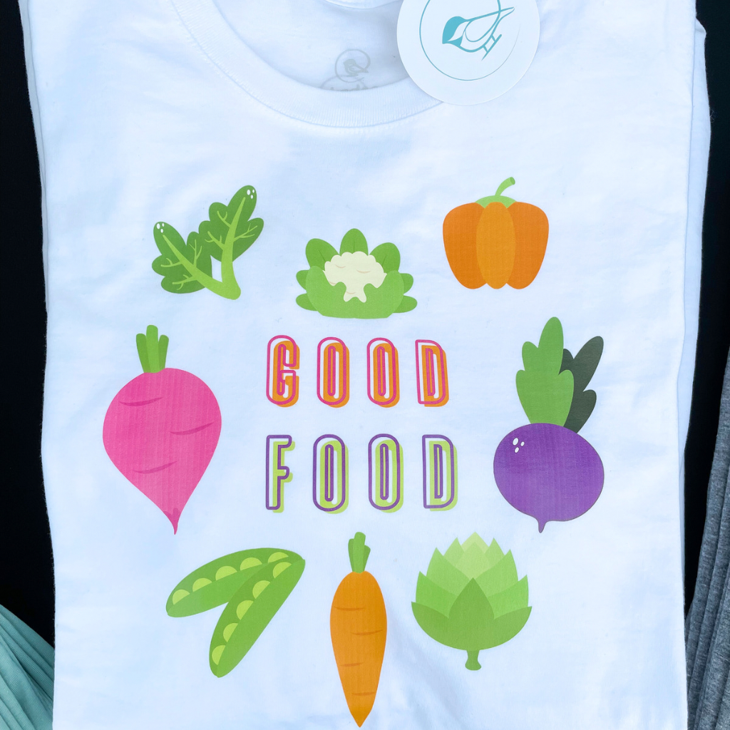100% organic cotton white unisex tshirt.  bright colored graphic shaped like a heart made out of vegetables with the words GOOD FOOD inside the heart.
