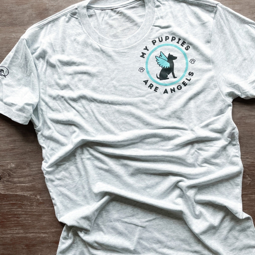 light salty white colored tshirt with upper left print saying 'my puppies are angels'.  circular design with dog and angel wing graphic in blue & black ink.  unisex sized vintage soft dog tshirt.