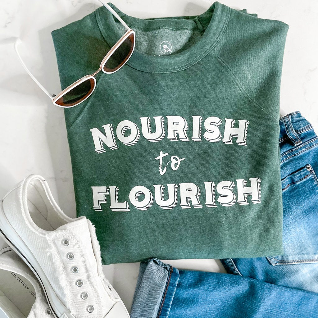 nourish to flourish green unisex crewneck sweatshirt.  super soft wellness apparel.  green sweatshirt with white ink saying ' nourish to flourish'.