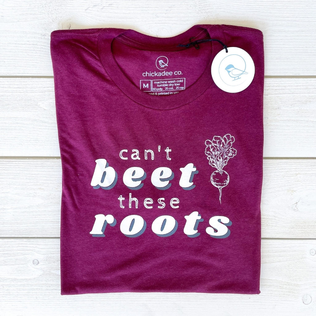 wellness tshirt by chickadee co. in a vibrant beet color.  chickadee co. wellness tshirt printed with the saying "can't beet these roots" & a graphic beet on the front.  wellness tshirts for women.