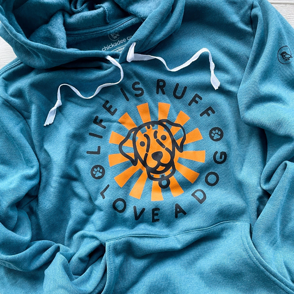 super soft dog hoodie for humans.  this turquoise blue hoodie is printed with a bright orange sun graphic & a black dog outline with the words LIFE IS RUFF, LOVE A DOG on the front chest.